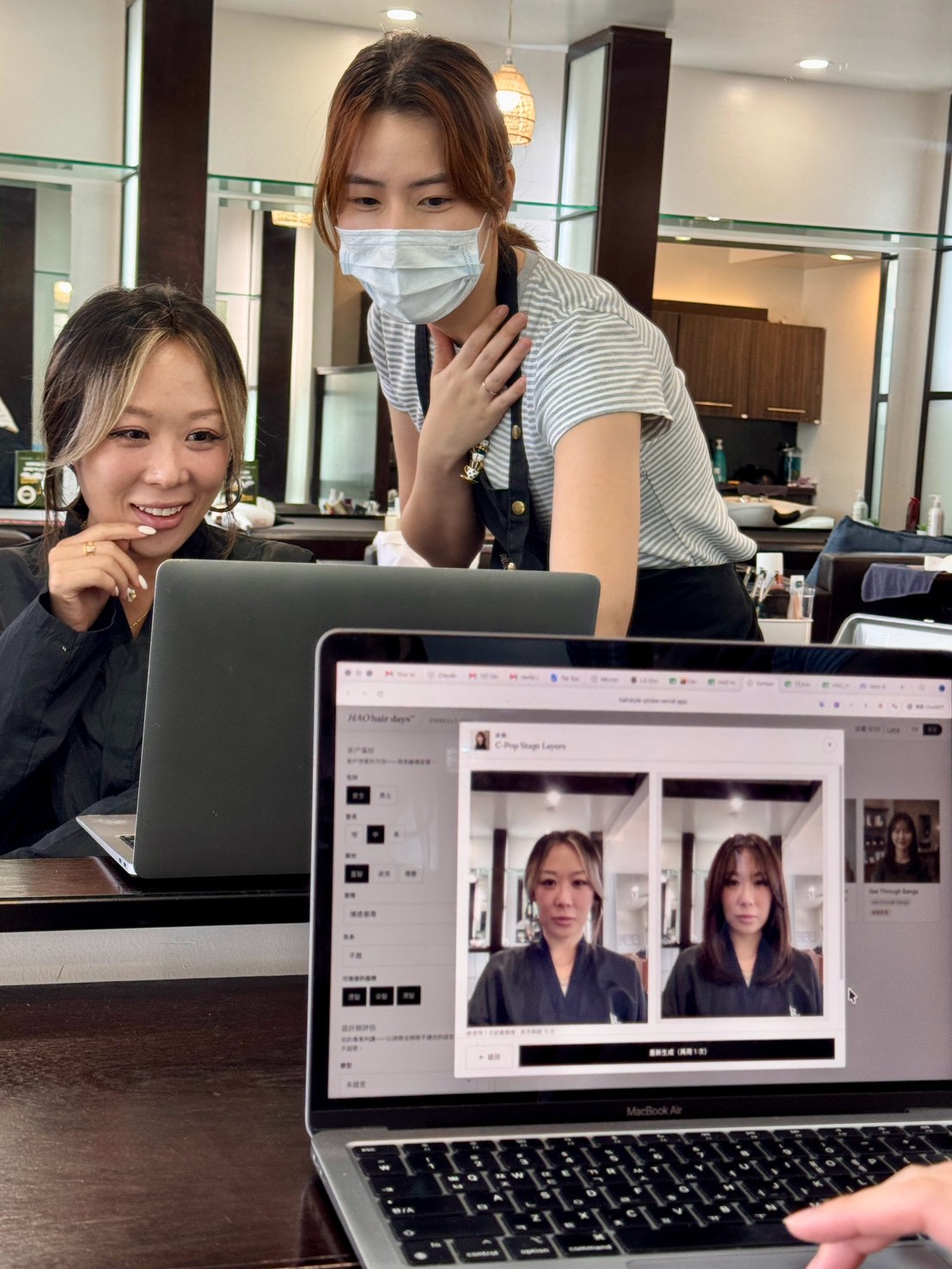 A stylist and her client at HAO hair days reviewing an AI-generated hairstyle try-on of the client in Consult Pro.
